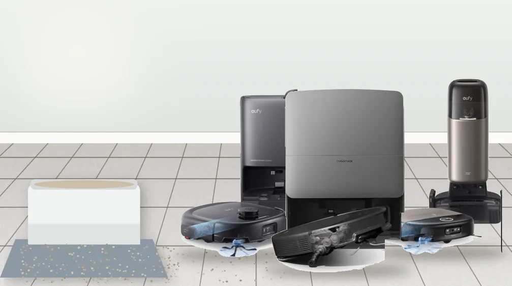 Three self-emptying robot vacuums with docks on a tiled floor next to a cat litter box with scattered litter