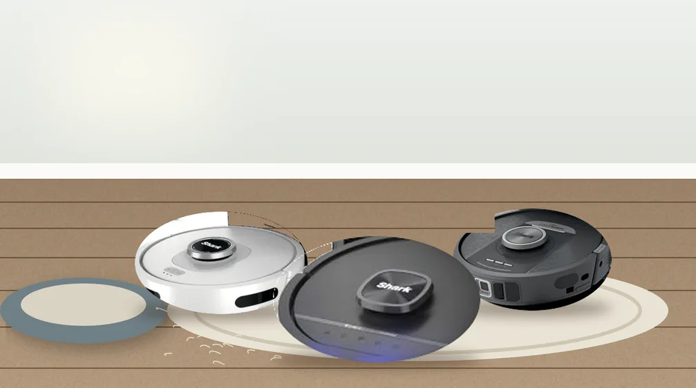 Three Shark robot vacuums on a living room rug next to a dog bed with pet hair