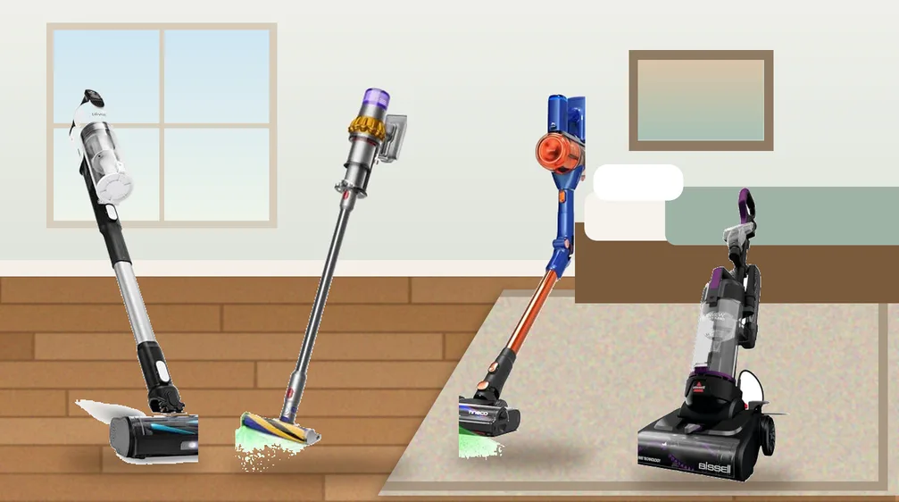 Cordless stick vacuums and a compact upright vacuum in a small studio apartment with a hardwood floor and area rug